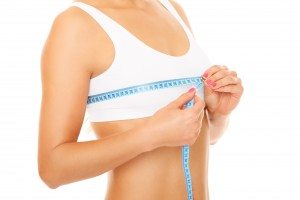 Women measures size of breast over white background